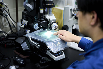 顕微鏡を使って作業している様子の写真